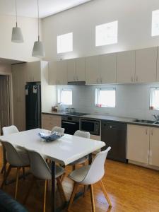 邓斯伯勒Cape Villas 23的厨房里有一张白色的桌子和白色的椅子