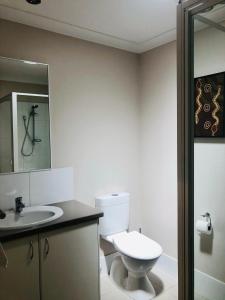 a bathroom with a toilet and a sink and a mirror at Cape Villas 23 in Dunsborough
