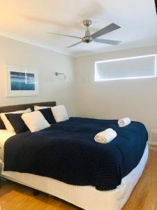 邓斯伯勒Cape Villas 23的一间卧室配有一张大床和吊扇
