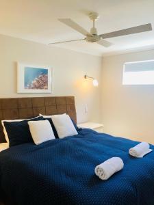 a bedroom with a blue bed with two towels on it at Cape Villas 23 in Dunsborough