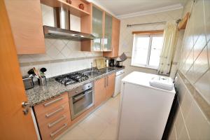 cocina con fregadero y fogones horno superior en Sandy Beach apartment, en Albufeira