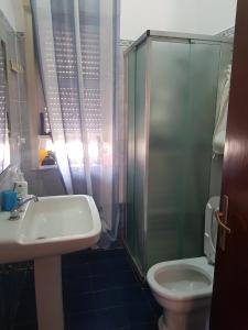 ein Bad mit einem Waschbecken, einer Dusche und einem WC in der Unterkunft Bilocale Jonio in Mascali