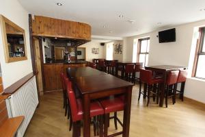 a dining room with wooden tables and red chairs at Gwesty Ty Newydd in Aberdaron +27 photos