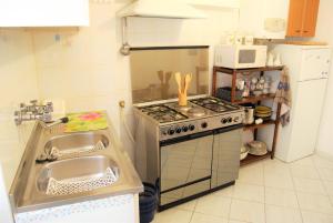 a small kitchen with a stove and a sink at A cà du Grillu - Casa Vacanze in Albisola Superiore