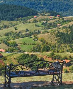 een bankje op een heuvel met uitzicht op een vallei bij Apartments NS Novaković in Zlatibor