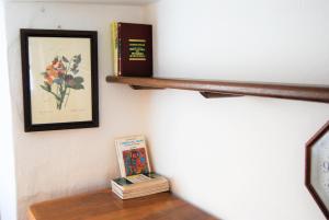 a shelf with books and a picture on a wall at A cà du Grillu - Casa Vacanze in Albisola Superiore