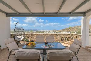 a patio with a table and chairs and a view at Sky View house in Agkidia
