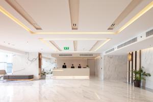 a lobby of a building with people standing at a counter at Jasmine 59 Hotel in Bangkok