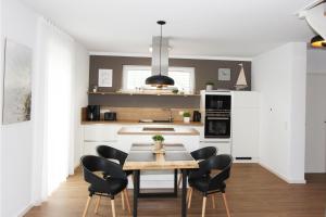 a kitchen with a dining room table and chairs at Blauwasser Luv in Zingst