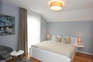 a bedroom with a large white bed and a table at Blauwasser Luv in Zingst