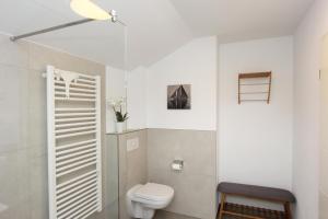 a white bathroom with a toilet and a sink at Blauwasser Luv in Zingst +18 photos