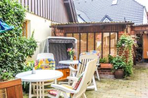 - un ensemble de tables et de chaises sur une terrasse dans l'établissement Likedeeler 5, à Zingst