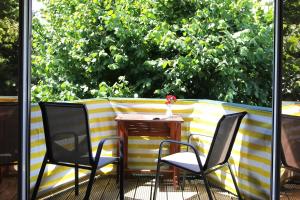 a table and two chairs on a patio with a fence at Lieblingshaus Fiete in Prerow