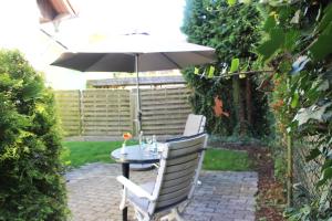 a table and two chairs with an umbrella at Lieblingshaus Eddie in Prerow +1 photo
