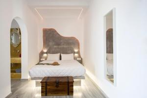 una camera da letto con un letto con una grande testiera di TheArtemis Perissa a Perissa