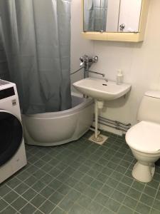 y baño con lavabo, bañera y aseo. en Spacious 1bdrm apartment near metro. Free parking en Vantaa