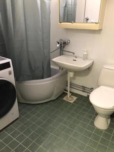 Un baño con lavabo, bañera e inodoro. en Spacious 1bdrm apartment near metro. Free parking, en Vantaa