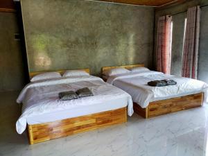 twee bedden in een kamer met schoenen erop bij Smile Box Coffee & Resort in Ban Nong Hin