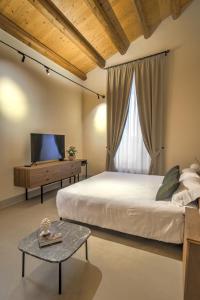 a bedroom with a bed and a tv and a table at Regina Bianca - Camere, Suite & Spa - Sciacca in Sciacca