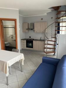 a kitchen with a table and a blue couch in a room at Room in Holiday house - Albavillage residence Large apartment for 4 people in Alba