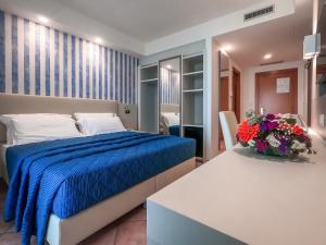 a bedroom with a bed and a table with flowers at Hotel Martino in Maratea