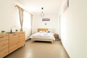a bedroom with a bed and a dresser and a window at Casa Adrian in Corbu