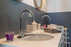 a bathroom with a sink with a purple glass on it at Villa Rosa del Garda in Garda