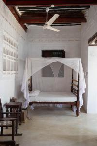 1 dormitorio con 1 cama con mosquitera en Makubwa House, en Lamu