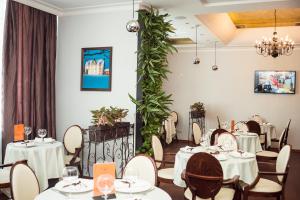un ristorante con tavoli, sedie e piante di Ost West Club a Samara