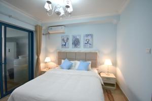 a bedroom with a large white bed with blue pillows at 晓院 Hue Garden in Huidong +107 photos