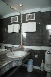 a bathroom with a sink and a toilet and towels at Mantenia Hotel in Platanes