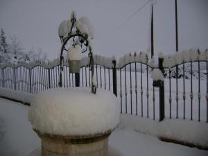 ein mit Schnee bedeckter Zaun neben einem Tor in der Unterkunft The Wishing Well in Gallinaro