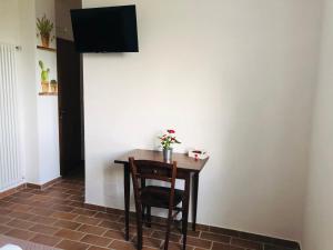 a small table with a chair and a television on a wall at Agriturismo LA VECCHIA CASCINA in Filattiera
