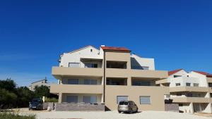 a building with two cars parked in front of it at Apartment Janja in Medulin