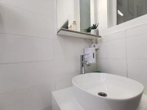 un bagno bianco con lavandino e specchio di Apartment Bačvice in Split a Spalato (Split)