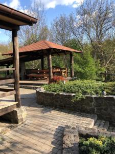 un pavillon avec une table et des bancs dans un jardin dans l'établissement Дом для отдыха в лесу, à Berëzovka