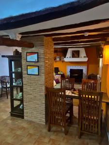 a dining room with a table and chairs and a fireplace at Vivelorural in Cuevas Labradas