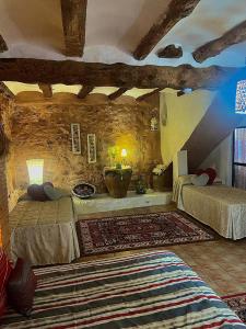 a bedroom with two beds and a stone wall at Vivelorural in Cuevas Labradas