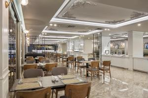 ein Restaurant mit Tischen und Stühlen und eine Bar in der Unterkunft Blue Marlin Deluxe Spa & Resort - Ultra All Inclusive in Konaklı