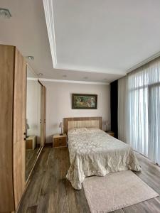 a bedroom with a bed and a large window at Villa Old Batumi in Batumi