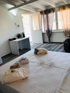 Cette chambre comprend un grand lit blanc et des rideaux. dans l'établissement Casa Vacanze Gallipoli Città Bella, à Gallipoli