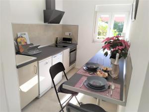 a small kitchen with a table with plates and flowers at Room in Studio - Apatrment Fantastico 4 - Puerto de la Cruz - Tenerife in Puerto de la Cruz