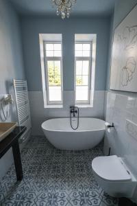 a bathroom with a tub and a toilet and a sink at Bellevue apartments Vila Vlasta Starý Smokovec in Smokovce