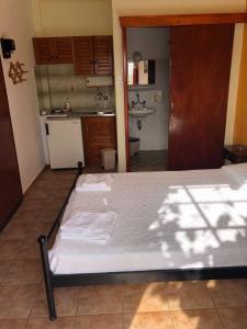 a large bed in a room with a kitchen at Villa Koula in Batsi