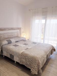a bedroom with a bed and a large window at VILLA BERNA in Alcudia