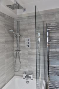 a bathroom with a shower and a bath tub with a sink at Newly Renovated 3 Bed Apartment with Parking by Ark SA in Sheffield