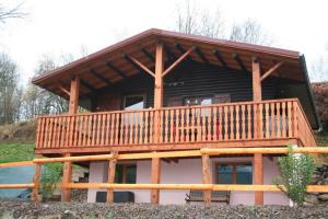 a large log cabin with a large deck at Le Chalet du bonheur , individuel avec belle vue in Laveline