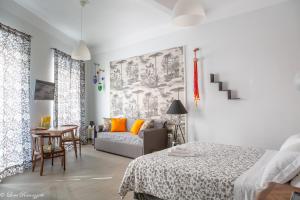 Cette chambre blanche dispose d'un lit et d'un canapé. dans l'établissement Janna 'e Mare, à Cagliari