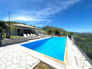 a swimming pool in front of a house at Lefkada Villas by Omikron Selections in Vavkerí