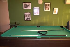un tavolo da biliardo verde in una stanza con immagini sul muro di Sunčana Sara a Tučepi